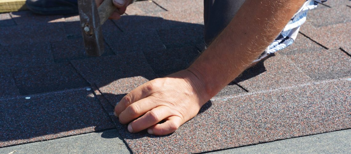 A man repairs shingles - Roofing Companies in Carroll County - Home Crafters Roofing & Contracting